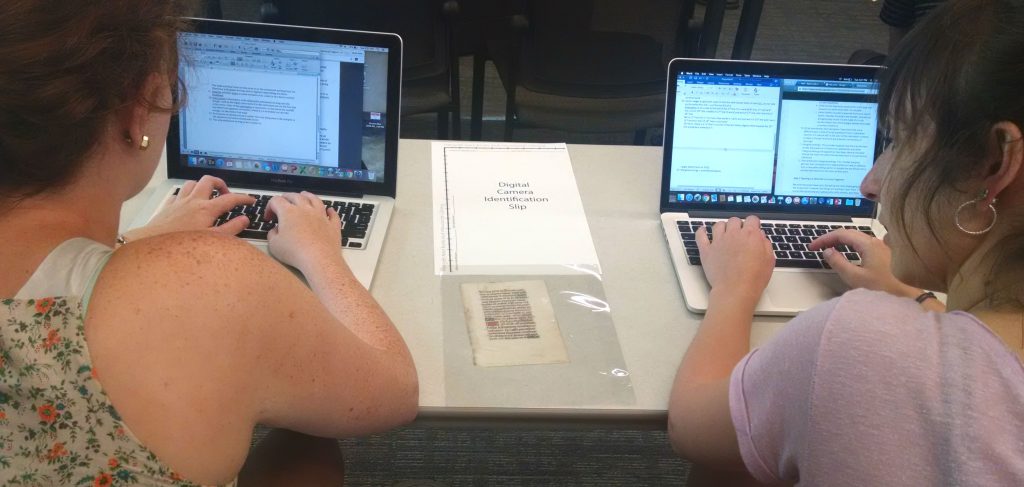 Two students examine a manuscript fragment