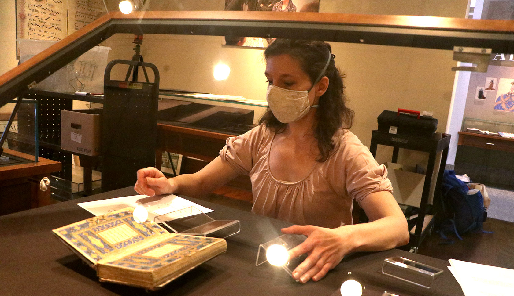 Dr Camp installs a Persian manuscript in an exhibit case in the Special Collections library