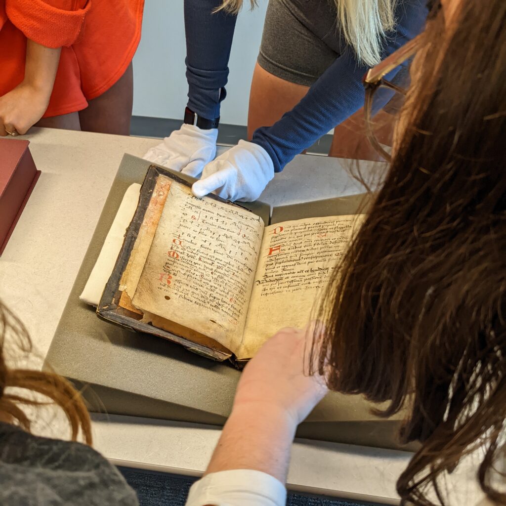 Students hold open an old book
