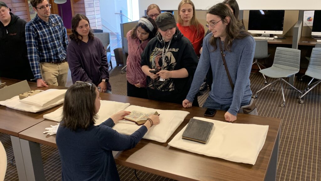 One woman holds open a book while other people look down at it