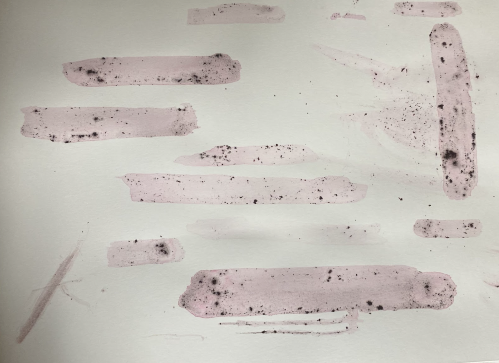 swatches of the cochineal lake with light pigmentation and grind deposits from brush.